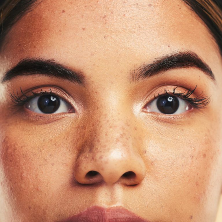 Woman, skin and closeup in studio portrait with beauty, cosmetics and natural glow on face by backg